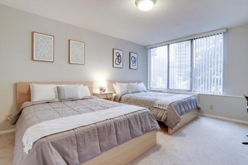 a bedroom with two beds and a large window at Style & Comfort from Luxurious condo at Crystal City in Arlington