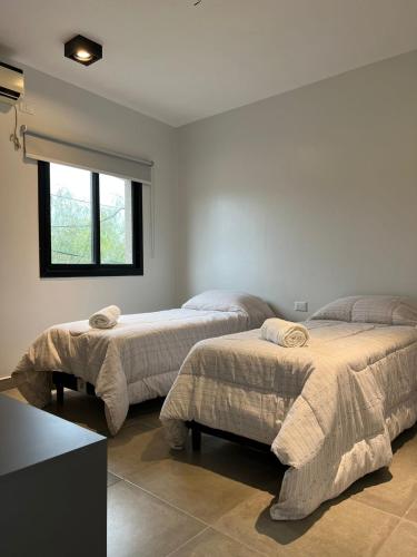 1 dormitorio con 2 camas y ventana en MODERNO DEPARTAMENTO PARA 3-4 PERSONAS, MUY BIEN UBICADO en Santiago del Estero
