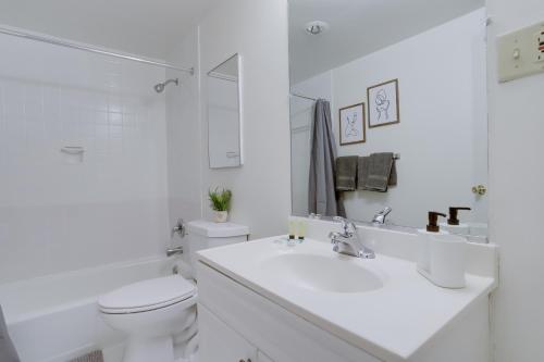 ein weißes Bad mit einem Waschbecken und einem WC in der Unterkunft Style & Comfort from Luxurious condo at Crystal City in Arlington