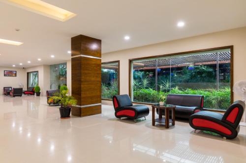 a waiting room at a hospital with chairs and tables at Monk's Nirvanaa Hotel & Resort in Indore