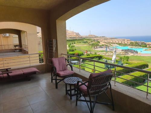 a balcony with chairs and a view of the ocean at Your Perfect Getaway with a Breathtaking Beach View in Ain Sokhna