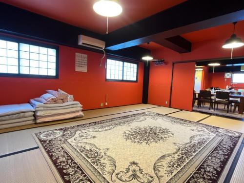 a room with a rug on the floor and red walls at Airport Osaka in Kaizuka