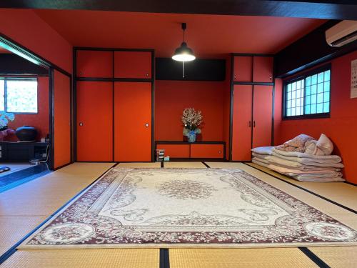 a room with red walls and a rug on the floor at Airport Osaka in Kaizuka