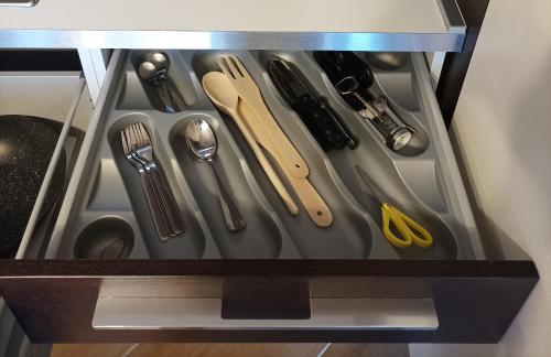 a drawer with silver utensils in a cabinet at Il nido in Alba