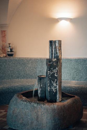 a fountain in a room with a couch at Apparthotel Sonnwies in Selva dei Molini