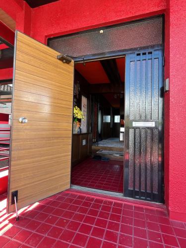 an open door of a red building with a red floor at Airport Osaka in Kaizuka