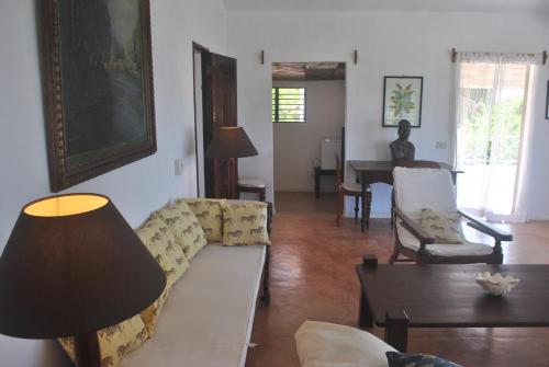 a living room with a couch and a table at Villa Palissandre in Nosy Be