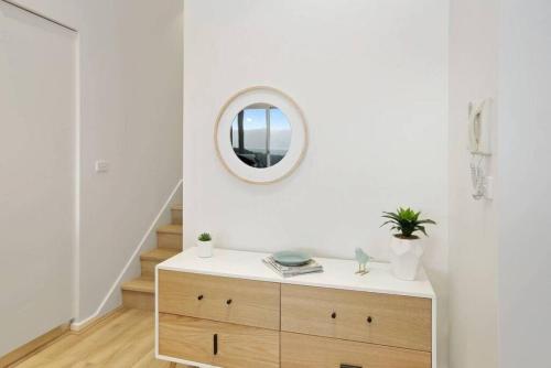a white room with a wooden dresser and a mirror at Bay Vue - Absolute Oceanviews in Apollo Bay