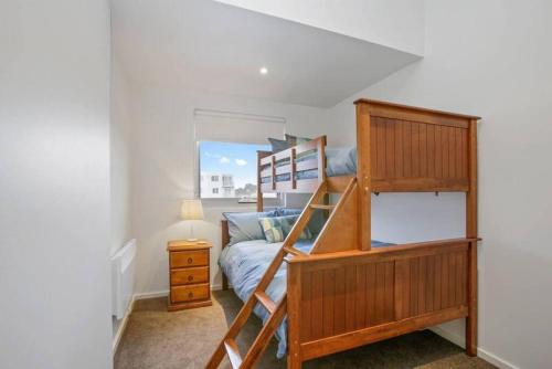 a small bedroom with a bunk bed and a ladder at Bay Vue - Absolute Oceanviews in Apollo Bay