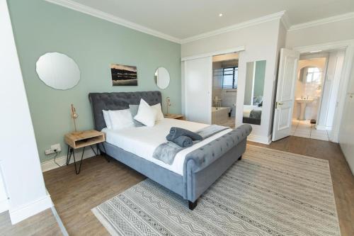 ポートエリザベスにあるStylish Apartment With Park Viewの広いベッドルーム(ベッド1台、鏡付)