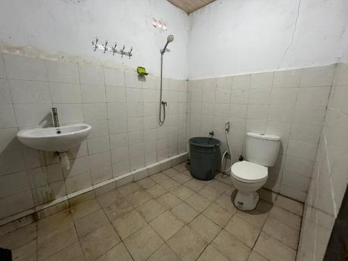 y baño con aseo y lavamanos. en Mangkombong Homestay, en Tapokreng