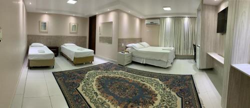 um quarto de hospital com duas camas e um tapete em Hotel Monte Libano em Paranaguá