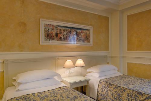 a hotel room with two beds and a picture on the wall at Hotel Continental Brescia in Roncadelle