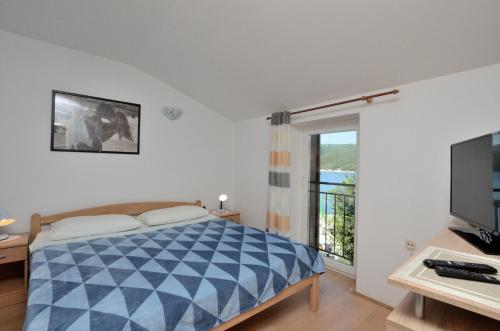 una camera con letto, TV e finestra di Apartments Lory a Rabac