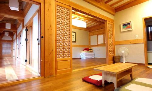 un soggiorno con tavolo e una camera con letto di Hwangnamguan Hanok Village a Gyeongju