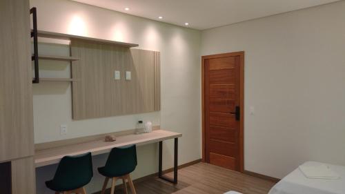 a bathroom with a sink and two chairs and a mirror at Pousada Boutique Raio de Luz in Ouro Preto