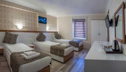 a hotel room with two beds and a couch at City Hotel Plovdiv in Plovdiv