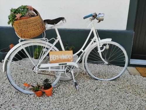a white bike with a basket and a sign on it at Castelo de Arez in Alcácer do Sal