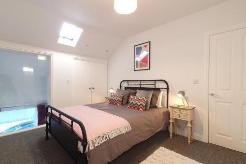 - une chambre avec un lit et une fenêtre dans l'établissement HUGE WOW FACTOR CENTRAL CHELTENHAM ABODE WITH POOL-TABLE AND PARKING, à Cheltenham