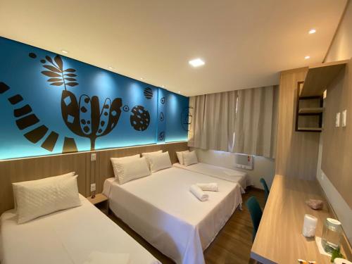 a hotel room with two beds and a table at Pousada Boutique Raio de Luz in Ouro Preto