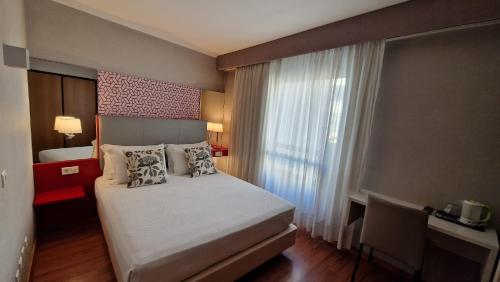 a bedroom with a bed and a large window at Hotel 3K Madrid in Lisbon