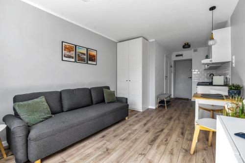 a living room with a couch and a kitchen at Warsaw City Center Studio - Park, Subway Nearby - by Rentujemy in Warsaw