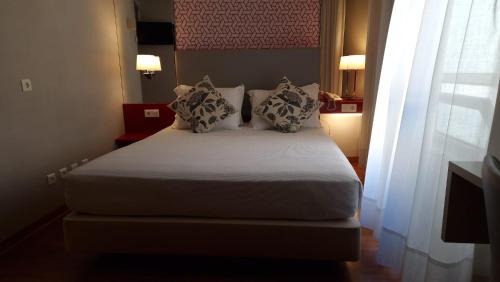 a bedroom with a bed with two pillows at Hotel 3K Madrid in Lisbon