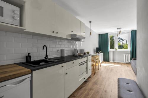 a kitchen with white cabinets and a counter top at Warsaw City Center Studio - Park, Subway Nearby - by Rentujemy in Warsaw