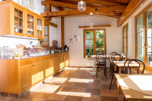 - une cuisine avec des placards en bois, une table et des chaises dans l'établissement Dorfpension Mariahilfberg, à Gutenstein