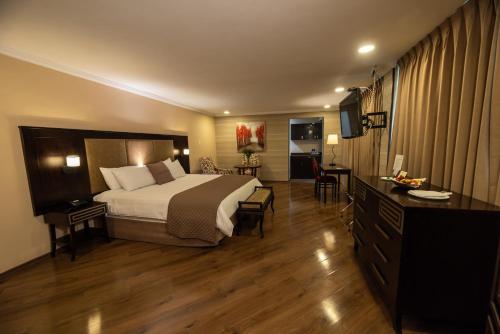 Habitación de hotel con cama y TV en Quindeloma Art Hotel & Gallery en Riobamba