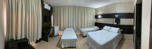 Habitación de hotel con cama y sofá en Hotel Monte Libano en Paranaguá