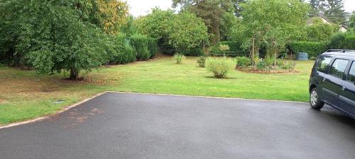 a car parked in a driveway next to a garden at Studio "l'aube du Perche" in La Mancelière
