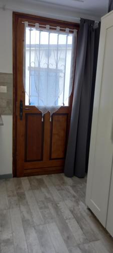 a wooden door with a window in a room at Studio "l'aube du Perche" in La Mancelière