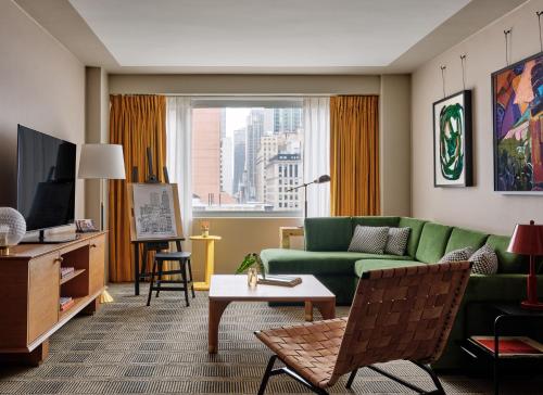 uma sala de estar com um sofá verde e uma janela em Romer Hell's Kitchen em Nova York