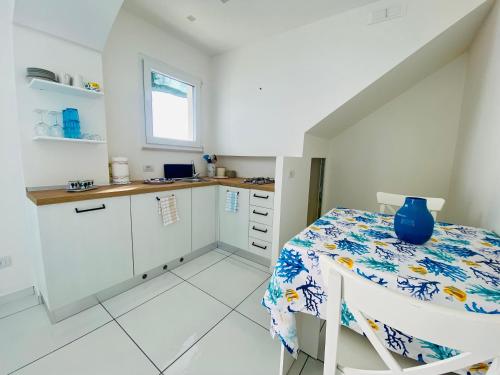 a kitchen with a table with a blue vase on it at Idillioravello in Ravello