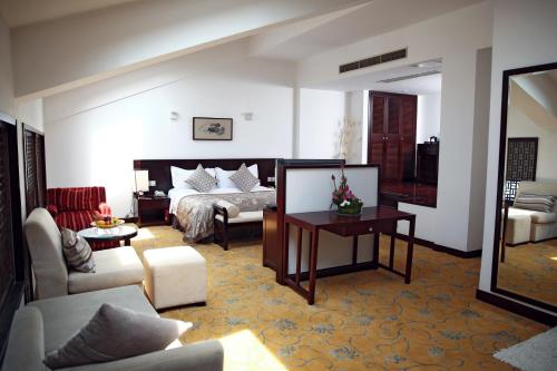 a living room with a bed and a couch at Garden Hotel Suzhou in Suzhou