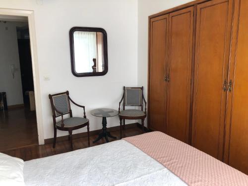 um quarto com 2 cadeiras, uma mesa e um espelho em Apartamento en el centro na Corunha