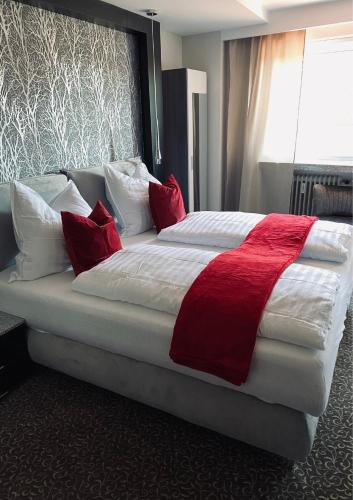 a bedroom with a large bed with red pillows at Ahorn-Zimmervermietung in Schrobenhausen