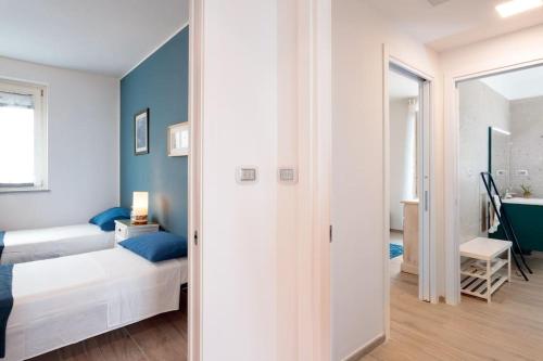 ein Schlafzimmer mit einem Bett und einer Wand mit blauen Akzenten in der Unterkunft Les Voiles - Trilocale sul mare in Ceriale