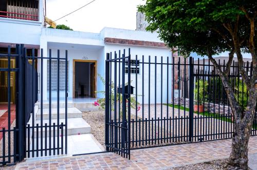 una puerta negra frente a una casa blanca en Hermosa casa en Costa de Oro, en Montería