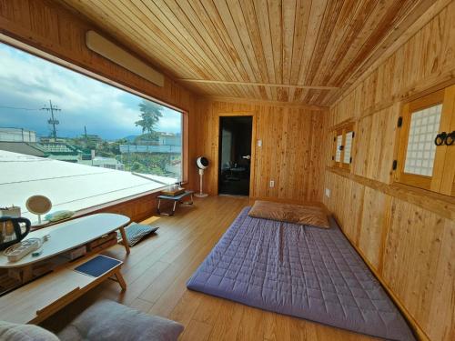 una camera con una grande finestra e un soffitto in legno di Today Jeju Yongdam a Jeju
