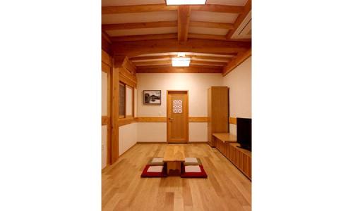 a room with wooden floors and a table in the middle at Hwangnamguan Hanok Village in Gyeongju