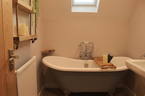 y baño con bañera y lavamanos. en Beautiful Cottage in the Heart of Stow on the Wold en Stow on the Wold