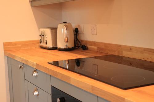 a kitchen counter with two toasters on top of it at Beautiful Cottage in the Heart of Stow on the Wold in Stow on the Wold