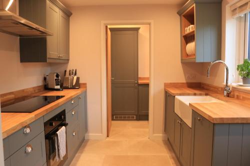 a kitchen with blue cabinets and a sink at Beautiful Cottage in the Heart of Stow on the Wold in Stow on the Wold