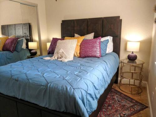 uma cama com um edredão azul e almofadas coloridas em Perfect Lake Retreat em Hot Springs