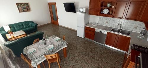 une petite cuisine avec une table et un canapé vert dans l'établissement Casa A.N.N.E., à Marghera
