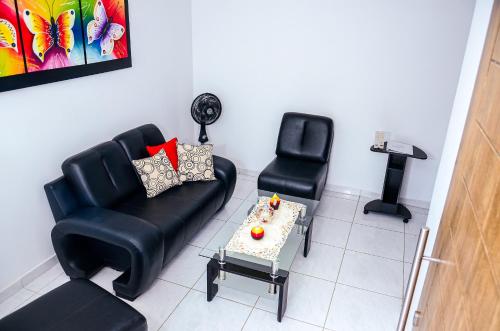 sala de estar con sofá y silla en Hermosa casa en Costa de Oro, en Montería