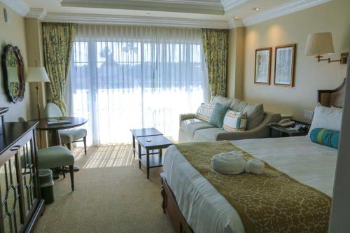 a hotel room with a bed and a living room at Disney’s Grand Floridian Resort in Orlando