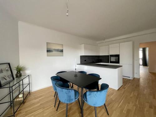 uma cozinha e sala de jantar com uma mesa e cadeiras azuis em U4 Spittelau TR10 em Viena